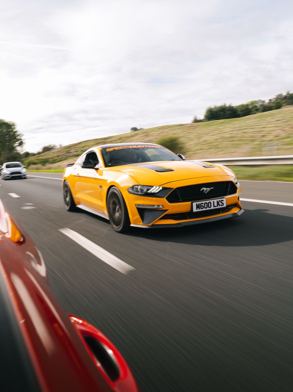 Orange Ford Mustang on the road